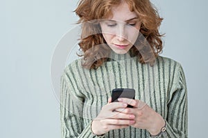 Pretty caucasian girl with red hair sending sms