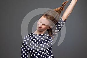 Pretty caucasian woman with damaged long gair trying to put off the scrunchy