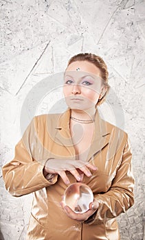 Pretty caucasian woman with her hands with crystal ball predicting the future on white background