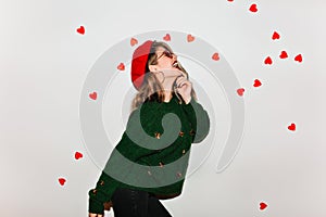 Pretty caucasian woman in woolen green sweater dancing on white background. Refined european female model in red french