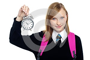 Pretty charming schoolgirl holding time piece