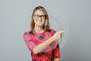 Pretty cheerful woman gesturing with fingers and hand and showing away