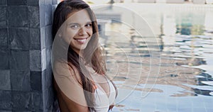 Pretty cheerful woman relaxing at poolside