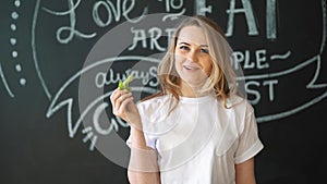 Pretty cheerful young woman posing with fresh green lettuce leaves. Healthy eating concept. Dieting.