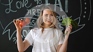 Pretty cheerful young woman posing with fresh green lettuce leaves. Healthy eating concept. Dieting.