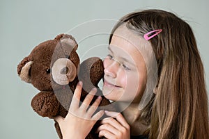 Pretty child girl playing with her teddy bear toy