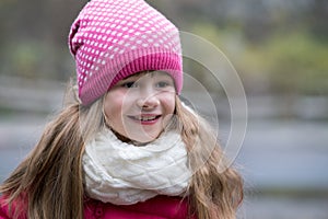 Pretty child girl in warm knitted winter clothes outdoors