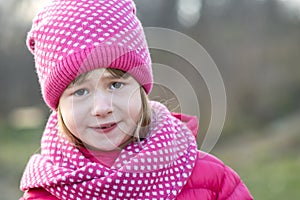 Pretty child girl in warm knitted winter clothes outdoors