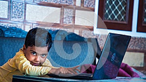 pretty child sitting at the table looking at camera screen and smiling. enjoying distance learning. close up