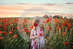 Pretty child young cute girl red dress stood in big poppy flower field countryside landscape view poppies dusk sunset golden hour
