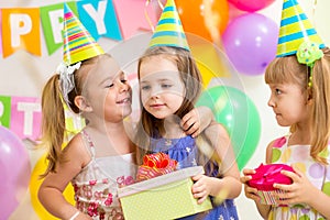 Pretty children giving gifts on birthday party