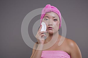 Pretty chinese woman taking care of her skin isolated from the background, beauty concept