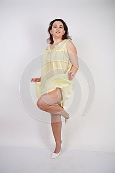 Pretty chubby girl wearing fashionable yellow underwear and loves her body and herself. plump woman in lingerie on white backgroun
