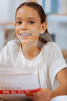 Pretty clever schoolgirl studying in a room