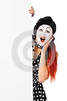 Pretty clown woman holding blank billboard