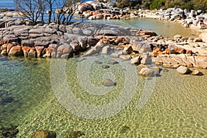 Pretty Coastal scene with turquoise waters rippled, rocky coastline at Skeleton Bay, part of Bay of Fires in Tasmania, Australia.