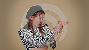 Pretty confident girl pointing around with finger gun gesture, making choice, shooting killing
