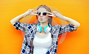 Pretty cool girl in sunglasses and headphones having fun