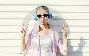 Pretty cool woman listens to music in headphones over white