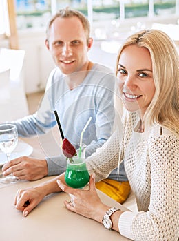 Pretty couple dating moment in cozy sunny restaurant