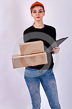 Pretty courier girl is holding cardboard parcels.