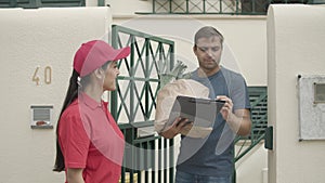 Pretty courier girl in red cap delivering food