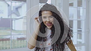 Pretty curly girl listens music with headphones