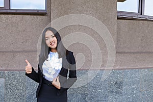 Pretty diligent student girl looks straight at camera, holds thu