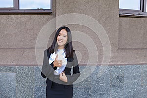 Pretty diligent student girl looks straight at camera, holds thu