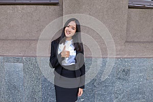 Pretty diligent student girl looks straight at camera, holds thu