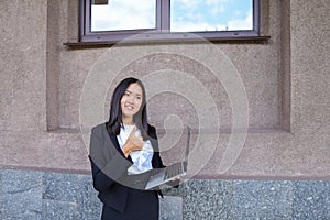 Pretty diligent student girl looks straight at camera, holds thu