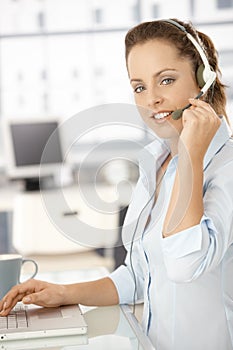 Pretty dispatcher working in bright office smiling