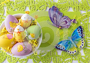 Pretty Easter eggs in a bowl on lime green background .