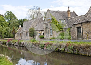 Pretty english village with stone houses, river, wild flowers