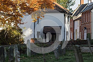 Pretty English village street and graveyard in autumn.