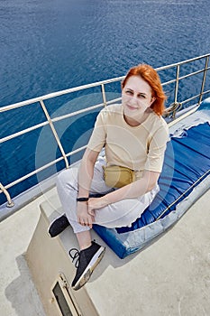 Pretty European woman poses for photographer on board yacht for sightseeing tours.