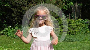 Pretty face little girl put sun glasses on head and show finger up at camera