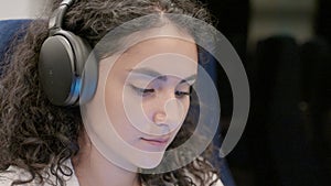 pretty face of young woman with headphones in suburban train or underground, female passenger