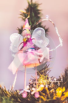 Pretty fairy angel decoration hanging from the top of an xmas tree