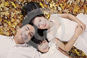 Pretty family relaxing on autumn leaves