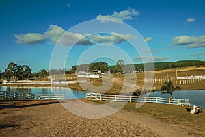 Pretty farm with fences, livestock sheds and lake