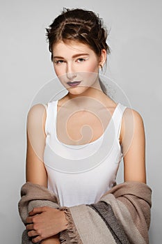Pretty fashion model with make up and unfinished hairdo. Clean fresh face of cute girl with red lips and white arrows on the eyes