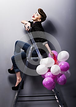 Pretty fashion retro teen girl laughing on ladder