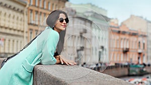 Pretty fashion woman enjoying amazing city architecture from river embankment relaxing outdoor