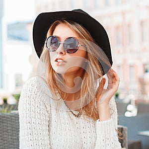 Pretty Fashionable woman with black hat and round sunglasses in