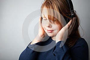 Pretty fat girl kid listens to music on headphones and gets pleasure