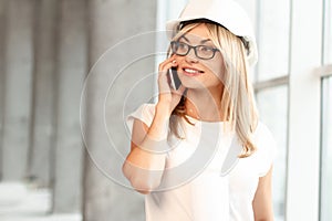 Pretty female architect talking on phone