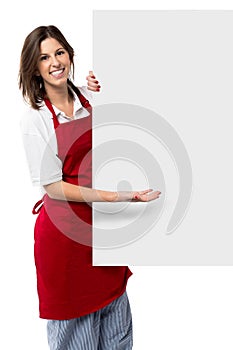 Pretty female chef holding a blank sign