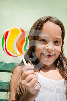 Pretty female child with lollipop smiling