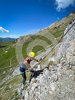 Pretty female climber on a steep Via Ferrata